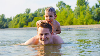 Father with son swimming in river
