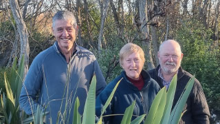 Boat Creek restoration group members Hamish Jones, Diane Clarke, and Andrew Clarke in front of an area where woody weeds will be removed over the next year.