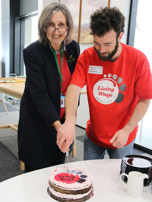 Outgoing Chair Jenny Hughey and Living Wage Movement community organiser Nathaniel Herz-Edinger celebrate with cake.